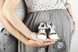 Newborn baby booties in parents hands. Close up.