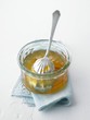 Orange marmalade in a glass dish with a spoon