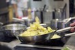 Potatoes being tossed in a pan