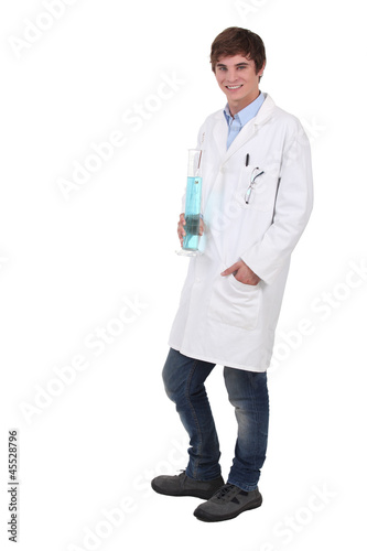 Photo: Teenage science student holding beaker full of blue liquid Teenage science student holding beaker full of blue liquid