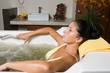 Beautiful young woman relaxing in jacuzzi filled with seawater