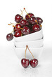 Fresh cherry berries in a stack of white ceramic bowls