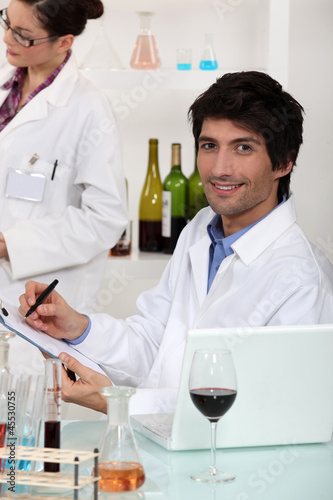 Photo: Man and woman conducting experiment on wine Man and woman conducting experiment on wine