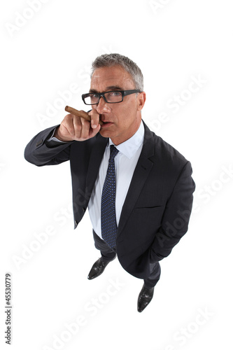 Photo: Senior businessman smoking cigar Senior businessman smoking cigar
