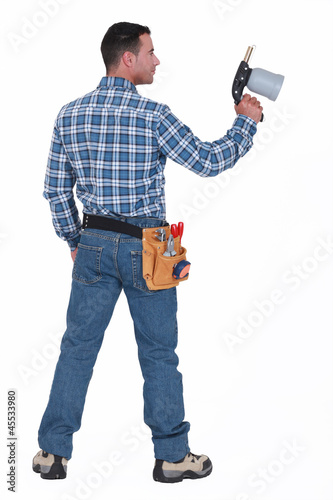 Photo: A male construction worker holding a welding torch. A male construction worker holding a welding torch.