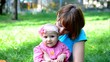Happy Mother and her baby girl enjoy playing outdoor