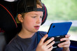 boy is playing electronic-game in the car