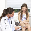 Female doctor checking child patient's reflex