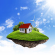 A piece of land in the air with house and tree.