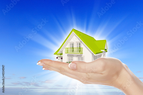 Photo: the house in hands on blue sky the house in hands on blue sky