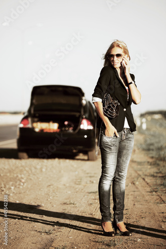 Photo: Young woman with broken car calling for help Young woman with broken car calling for help