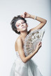 Enigma. Fantasy. Retro fashion woman with white vintage fan
