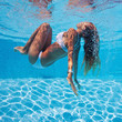 Photo: Underwater woman portrait with white bikini in swimming pool. Underwater woman portrait with white bikini in swimming pool.