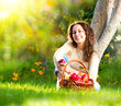 Photo: Beautiful Girl Eating Organic Apple in the Orchard Beautiful Girl Eating Organic Apple in the Orchard
