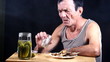Man drinks and bites pickle