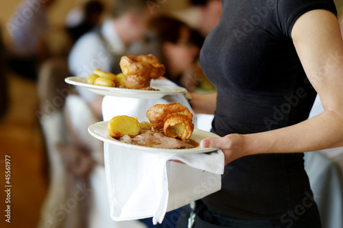 Photo: Waitress carrying two plates with meat dish Waitress carrying two plates with meat dish