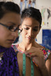 Fashion designer using measuring tape with client