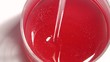 juice flowing into a glass, bubbles shimmering here and there