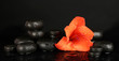 Spa stones with gladiolus bud isolated on black