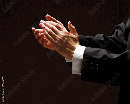 Photo: Male hands clapping on black, side-view Male hands clapping on black, side-view