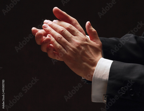 Photo: Male hands clapping on black, side-view Male hands clapping on black, side-view