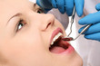 A dentist examinig patient's teeth, close-up, image