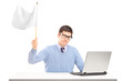 Sad man sitting with laptop and holding a white flag gesturing d