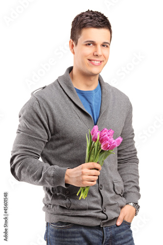 Photo: Smiling handsome male holding tulips Smiling handsome male holding tulips