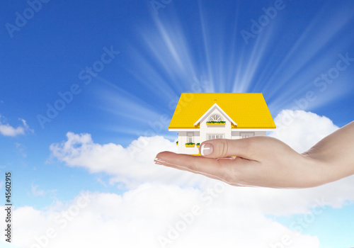 Illustration: the house in hands on blue sky the house in hands on blue sky