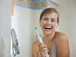 Happy young woman after brushing teeth with electric toothbrush