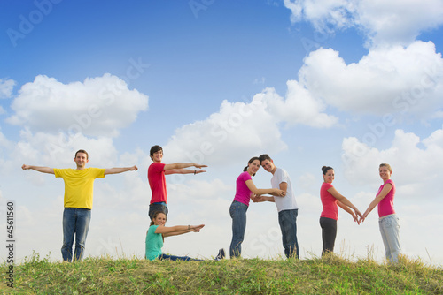 Photo: Group of people spelling word TEAM outdoors in nature Group of people spelling word TEAM outdoors in nature