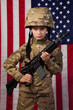 Boy USA soldier in front of American flag with rifle