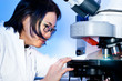 Photo: Young oriental scientist tunes her microscope Young oriental scientist tunes her microscope