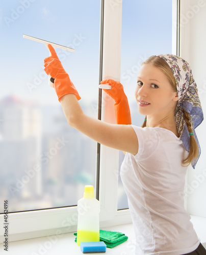 Photo: young housewife washing the window young housewife washing the window