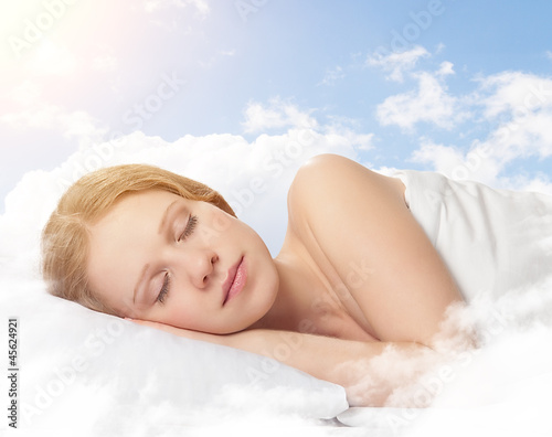Photo: beautiful young woman sleeping on a cloud in the sky beautiful young woman sleeping on a cloud in the sky