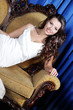 Photo: young beautiful elegant woman sitting in armchair young beautiful elegant woman sitting in armchair