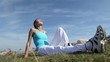 Woman in fitness outfit relaxing outside in countryside