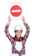 Female manual worker holding warning sign
