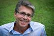 homme souriant assis dans l'herbe