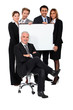Four executives holding a board behind their boss