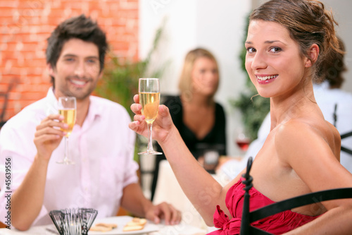 Photo: Man and woman holding champagne glasses in restaurant Man and woman holding champagne glasses in restaurant