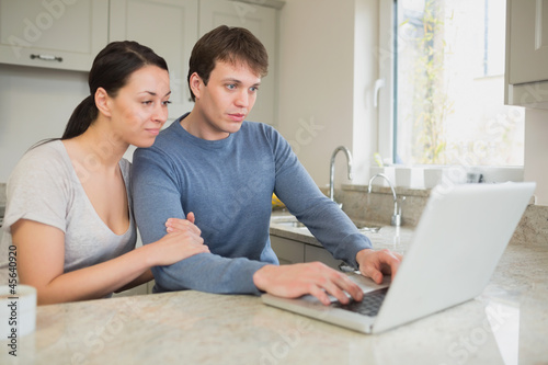 Photo: Couple looking at laptop Couple looking at laptop