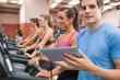 Male gym instructor with women on treadmills