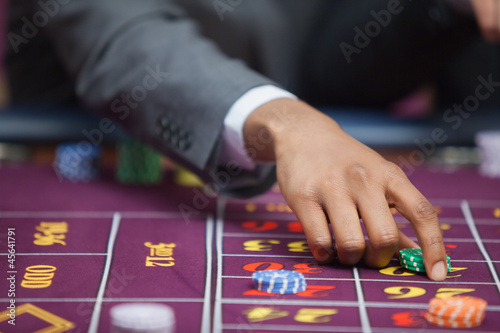 Photo: Man in casino placing bet Man in casino placing bet