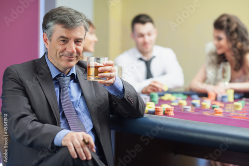 Photo: Man drinking whiskey at roulette table Man drinking whiskey at roulette table