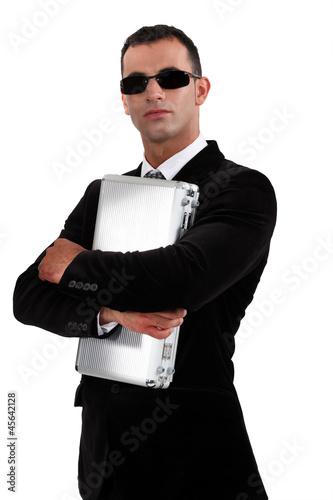 Photo: Man in sunglasses protecting briefcase Man in sunglasses protecting briefcase