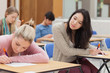 Girl copying another students work in exam