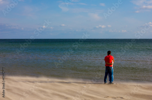 Photo: young couple embracing on a sandy beach young couple embracing on a sandy beach