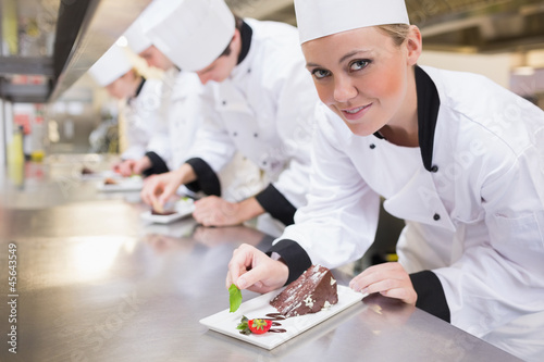 Photo: Smiling chef looking up from finishing dessert Smiling chef looking up from finishing dessert