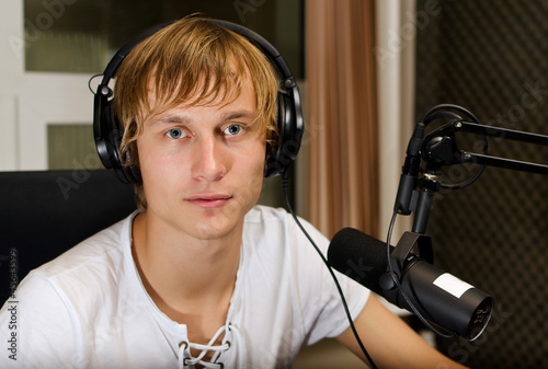 Photo: Male dj working in front of a microphone on the radio Male dj working in front of a microphone on the radio